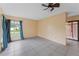 Bedroom featuring a ceiling fan, tile flooring, and a sliding glass door to the backyard at 15635 Bear Creek Dr, Tampa, FL 33624