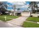 Well-maintained single-story home with a large driveway and manicured landscaping at 15635 Bear Creek Dr, Tampa, FL 33624