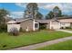 Attractive single-story home featuring a manicured lawn, lush landscaping and attached garage at 15635 Bear Creek Dr, Tampa, FL 33624