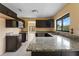 Kitchen featuring dark cabinetry, granite counters, and a stainless steel sink under a window at 15635 Bear Creek Dr, Tampa, FL 33624