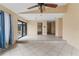 Open living room featuring tiled floors, a ceiling fan, and glass sliding doors to the outside at 15635 Bear Creek Dr, Tampa, FL 33624