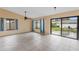 Bright living room with tile floors, large windows, and a sliding glass door to the backyard at 15635 Bear Creek Dr, Tampa, FL 33624