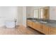 Elegant bathroom featuring a soaking tub, dual vanity with stone countertops, and wood-look tile flooring at 2912 Santiago St # 1201, Tampa, FL 33629