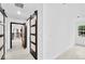 Bright hallway with white walls, light wood flooring, and barn door at 1105 Conant Ave, Safety Harbor, FL 34695
