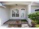 Inviting house exterior featuring a covered entryway, patterned tile porch and landscaping at 1839 Sunrise Dunes Ct, Tarpon Springs, FL 34689