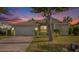 Evening view of charming one-story house with landscaped yard at 1839 Sunrise Dunes Ct, Tarpon Springs, FL 34689