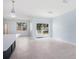 Open concept kitchen with island, white cabinets, and access to backyard patio at 1839 Sunrise Dunes Ct, Tarpon Springs, FL 34689