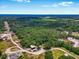 Drone shot shows the property's vast tree coverage, proximity to the airport and commercial development at 0 Castlewood Rd # Lot 3, Seffner, FL 33584