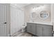 Bathroom with gray vanity, white shower curtain and circular mirrors at 13029 Paddock Wood Pl, Riverview, FL 33579
