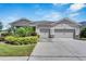 Single-story home with a three-car garage and landscaped front yard at 13012 Rain Lily Dr, Riverview, FL 33579