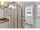 Walk-in shower with glass enclosure and a window for natural light at 13012 Rain Lily Dr, Riverview, FL 33579