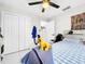 Bright bedroom featuring a ceiling fan, closet, and accent wall hanging above the bed at 4477 67Th N St, St Petersburg, FL 33709