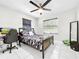 Comfortable bedroom featuring a camo-themed bed, ceiling fan, and a desk area, ideal for rest and productivity at 4477 67Th N St, St Petersburg, FL 33709