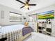 Bright bedroom with a ceiling fan, window, and a media center with shelves, all contributing to a comfortable aesthetic at 4477 67Th N St, St Petersburg, FL 33709