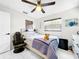 Bright bedroom with a ceiling fan, a large window, and an accent wall hanging above the bed at 4477 67Th N St, St Petersburg, FL 33709