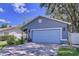 Charming single-story home features a blue garage door, manicured lawn, and cozy porch at 4477 67Th N St, St Petersburg, FL 33709