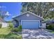 Charming single-story home features a blue garage door, manicured lawn, and cozy porch at 4477 67Th N St, St Petersburg, FL 33709