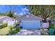 Charming single-story home features a blue garage door, manicured lawn, and cozy porch at 4477 67Th N St, St Petersburg, FL 33709