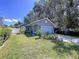 Charming single-story home featuring a well-manicured lawn, a blue garage door and mature trees at 4477 67Th N St, St Petersburg, FL 33709