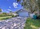 Attractive one-story home with a blue garage door, a lush front lawn and large mature shade trees at 4477 67Th N St, St Petersburg, FL 33709