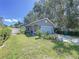 Charming single-story home featuring a well-manicured lawn, a blue garage door and mature trees at 4477 67Th N St, St Petersburg, FL 33709