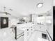 Bright open kitchen features white cabinets, stainless appliances, a large island, and elegant lighting fixtures at 4477 67Th N St, St Petersburg, FL 33709