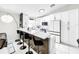Kitchen with white cabinetry, a black and white quartz breakfast bar, and black hardware and appliances at 4477 67Th N St, St Petersburg, FL 33709