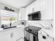 Kitchen with large window, white cabinets, stainless steel appliances, and black hardware at 4477 67Th N St, St Petersburg, FL 33709