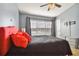 Spacious bedroom with red accents and large window at 4538 Kennewick Pl, Riverview, FL 33578