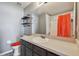 Bathroom with dark vanity, patterned floor, and coral accents at 4538 Kennewick Pl, Riverview, FL 33578