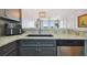 Modern kitchen with gray cabinets, stainless steel appliances, and a granite countertop at 4538 Kennewick Pl, Riverview, FL 33578