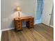 Hardwood floors, light grey walls and a classic desk are the highlights of this bedroom at 120 Knollpoint Dr, Sun City Center, FL 33573