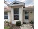 Charming home entrance featuring decorative shutters, house number and well maintained landscaping at 120 Knollpoint Dr, Sun City Center, FL 33573