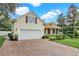 Two-story house with a large garage and landscaped yard at 1025 Misty Hollow Ln, Tarpon Springs, FL 34688