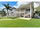 Backyard with patio, putting green, and two-story house at 833 Bay Point Dr, Madeira Beach, FL 33708