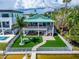 Elevated view of two-story home, showcasing backyard oasis, and dock at 833 Bay Point Dr, Madeira Beach, FL 33708