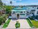 Two-story waterfront home with a large driveway and green lawn at 833 Bay Point Dr, Madeira Beach, FL 33708