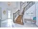 Grand two-story entry with a wooden staircase and tile floors at 2924 Valencia Ridge St, Valrico, FL 33596