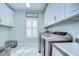 Bright laundry room with white cabinets and modern appliances at 2924 Valencia Ridge St, Valrico, FL 33596