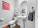 Elegant powder room with pedestal sink and arched mirror at 4586 Grand Lakeside Dr, Palm Harbor, FL 34684