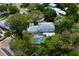 An aerial view showcases the home, backyard pool, and surrounding lush greenery at 31 Island Way # 907, Clearwater Beach, FL 33767