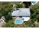 An aerial view shows the house, pool, screened in patio, and surrounding landscaping at 31 Island Way # 907, Clearwater Beach, FL 33767