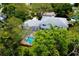 Aerial view of a backyard with a sparkling in-ground pool and lush green trees providing privacy at 31 Island Way # 907, Clearwater Beach, FL 33767