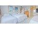 Light bedroom with three twin beds, featuring beach-themed decor and neutral walls at 31 Island Way # 907, Clearwater Beach, FL 33767