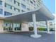 Exterior view of Horizon House with a covered entrance, landscaping and visitor parking at 31 Island Way # 907, Clearwater Beach, FL 33767