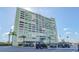 Exterior view of condo building showcases a towering structure with lush landscaping and ample parking at 31 Island Way # 907, Clearwater Beach, FL 33767