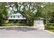 Charming two-story home with a brick facade, balcony, manicured lawn, mature trees, and two car garage at 31 Island Way # 907, Clearwater Beach, FL 33767