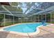 A screened-in pool with brick pavers surrounds a sparkling pool with ladder entry in a private backyard setting at 31 Island Way # 907, Clearwater Beach, FL 33767