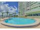 Community pool with inviting pool and ample seating, with a backdrop of lush landscaping and water views at 31 Island Way # 907, Clearwater Beach, FL 33767