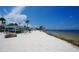 Scenic beach view with white sand, palm trees, clear blue skies, and tranquil water perfect for relaxation at 4737 Casswell Dr, New Port Richey, FL 34652